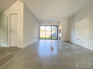 Hall de entrada com piso de cerâmica e porta de vidro que dá para o exterior.