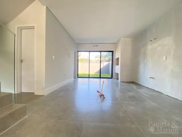 Hall de entrada com piso de cerâmica e porta de vidro que dá para o exterior.