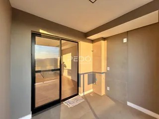 Ambiente interno com porta de vidro e piso de madeira.