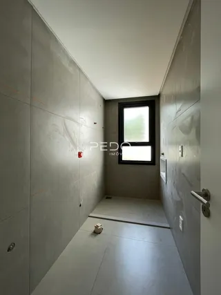 Corredor interno de um imóvel com paredes lisas e piso claro.