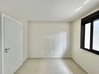 Interior de uma sala com paredes brancas e piso claro.