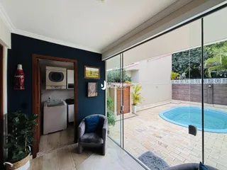 Vista da sala de estar com acesso a uma área externa com piscina.