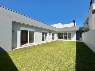 Fachada de casa moderna com grande gramado verde.