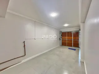 Vista interna de um ambiente amplo com paredes brancas e piso claro.