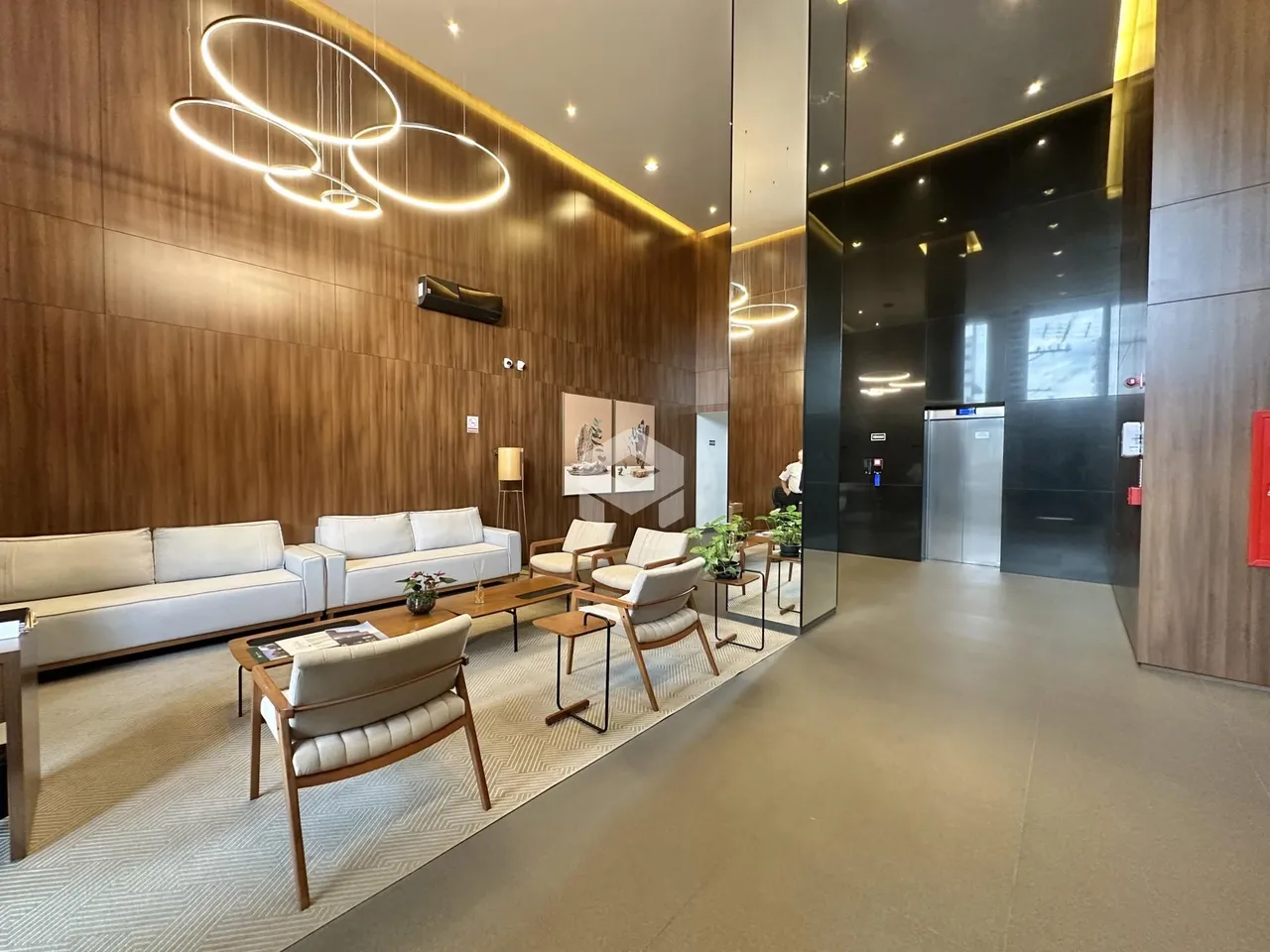 Sala de estar moderna com paredes de madeira e decoração contemporânea.