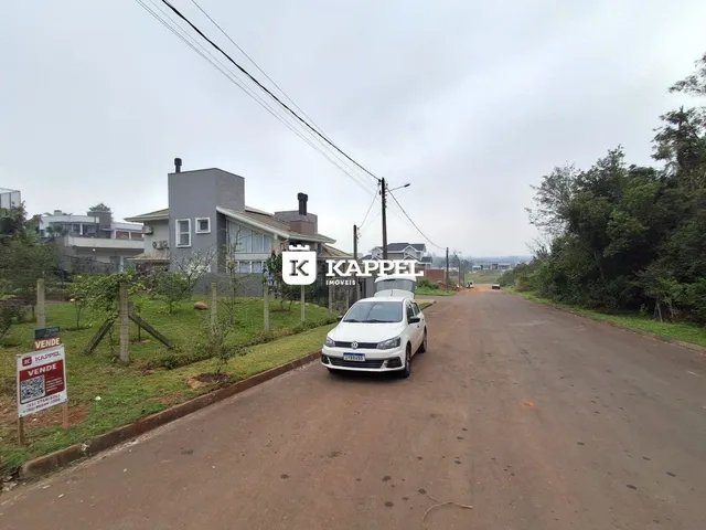 Vista externa de uma rua residencial em Lajeado, Brasil, com casas ao fundo.