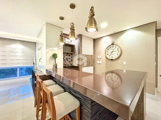 Vista de uma cozinha moderna com ilha e área de jantar.