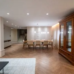 Sala de estar com piso de madeira e painéis de madeira.