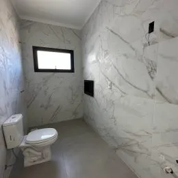 Foto de um banheiro com paredes revestidas em mármore branco.
