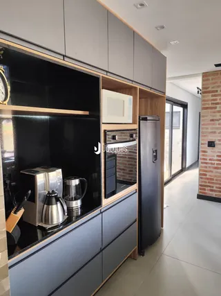 Foto de uma cozinha moderna com armários escuros e eletrodomésticos de aço inoxidável.