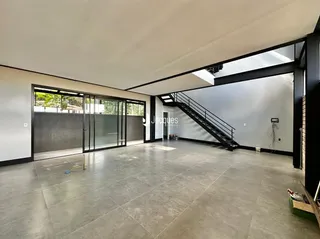 Vista ampla de um espaço interno com piso de cerâmica e portas de vidro.