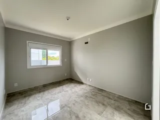 Imagem de uma sala de estar com piso de cerâmica e janela.