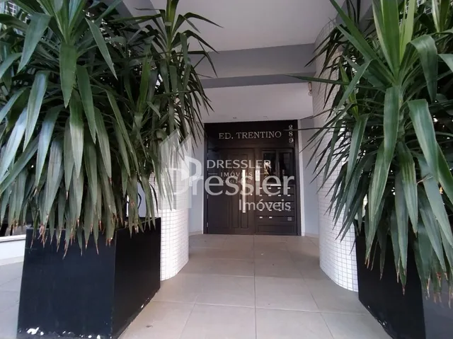 Corredor interno com plantas em vasos em uma residência.