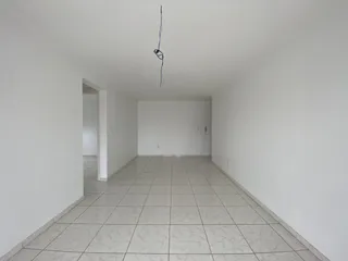 Corredor longo com piso de azulejos claros e paredes brancas.