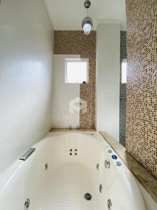 Banheira em um banheiro com revestimento de azulejos.