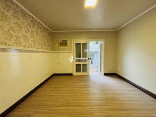 Sala de estar com piso de madeira e papel de parede na Lajeado.