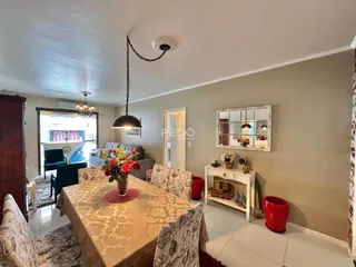 Ambiente interno de sala de jantar com decoração de madeira e paredes neutras.