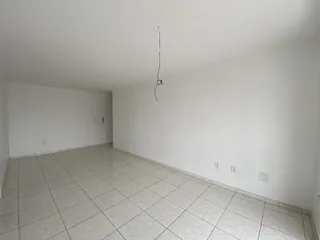 Foto de um cômodo amplo com piso de cerâmica e paredes brancas.
