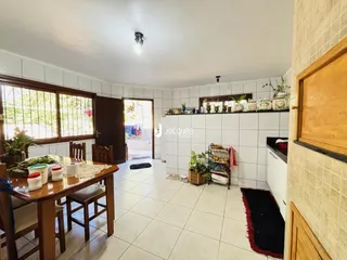 Interior de uma sala com piso de cerâmica e mesa de madeira.