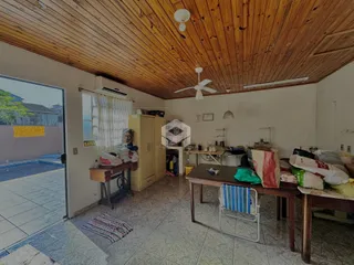Interior de uma sala com teto de madeira e acesso a uma área externa.