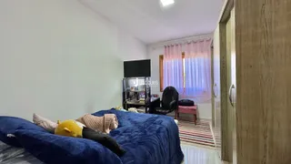Quarto com cama grande e paredes brancas em um imóvel no Brasil.