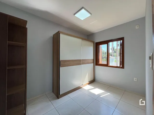 Quarto com armário e janela em ambiente claro.