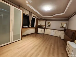 Sala de estar com piso de madeira clara e armários embutidos.