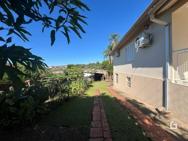 Fachada de uma residência em Lajeado, Brasil, com jardim e caminho de tijolos.