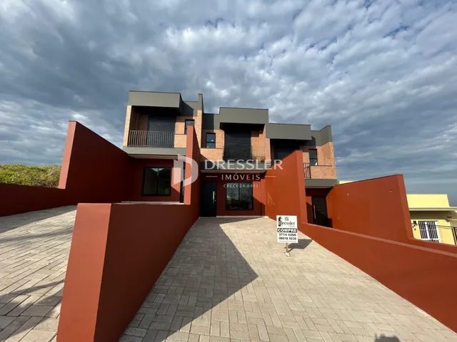 A fachada de uma residência em Lajeado, Brasil, com paredes em tom terracota.