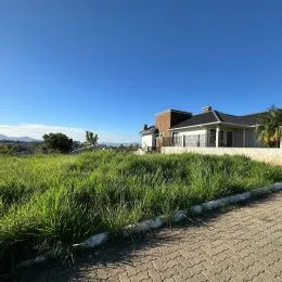 Fachada de uma casa com gramado e paisagem em Lajeado.