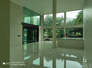 Sala de estar com grandes janelas de vidro que refletem o ambiente.