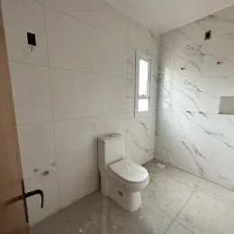 Foto de um banheiro interno com paredes brancas e piso de cerâmica.