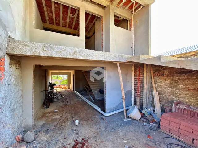 Vista da fachada de uma construção em Lajeado, Brasil com paredes de concreto expostas.