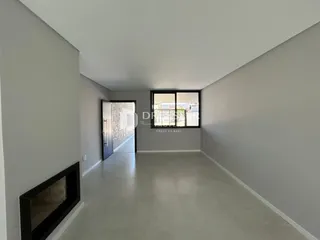 Hall de entrada com paredes brancas e piso claro.