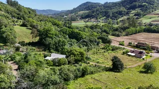 Vista panorâmica de paisagem rural com colinas verdes e vegetação densa.