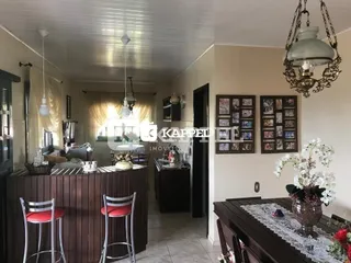 Foto de uma área de cozinha com bancada de madeira e banquetas.