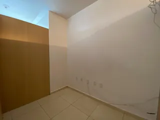 Vista interna de um cômodo com paredes brancas e piso de cerâmica.