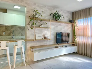 Sala de estar moderna com parede de tijolos e estantes de madeira.