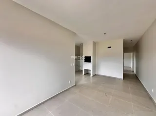 Vista de um corredor interno com paredes brancas e piso claro.