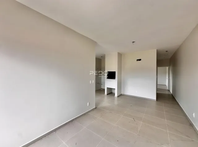 Vista de um corredor interno com paredes brancas e piso claro.