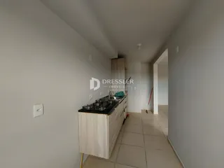 Vista interna de uma cozinha com armários e piso claro.