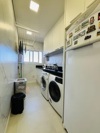 Interior de um corredor com armários e máquinas de lavar roupa.