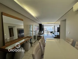 Interior de uma sala de estar moderna com grandes janelas e móveis de madeira.
