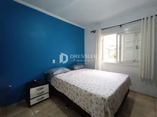 Quarto com parede azul e janela iluminada.