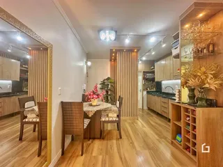 Ambiente interno de uma sala de jantar com piso de madeira clara.