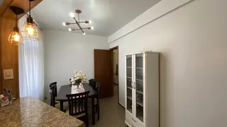 Foto de um ambiente de jantar com mesa escura e cadeiras em um apartamento.