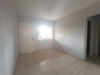 Ambiente interno de uma sala com piso de cerâmica e portas brancas.