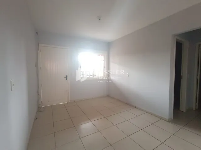 Ambiente interno de uma sala com piso de cerâmica e portas brancas.