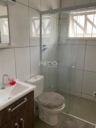 Foto do interior de um banheiro com box de vidro transparente.