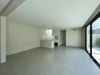 Ambiente interno de uma sala ampla com piso de concreto.